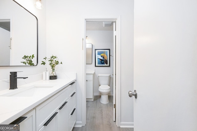 bathroom with vanity, wood-type flooring, and toilet