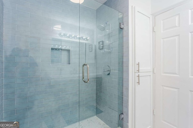 bathroom with a shower with door