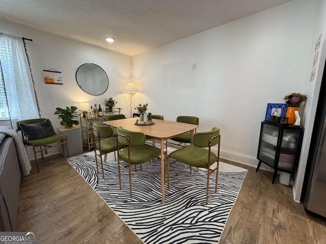 dining room with dark hardwood / wood-style floors and a textured ceiling