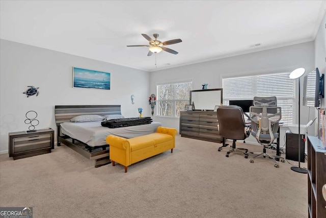 carpeted bedroom featuring ornamental molding and ceiling fan