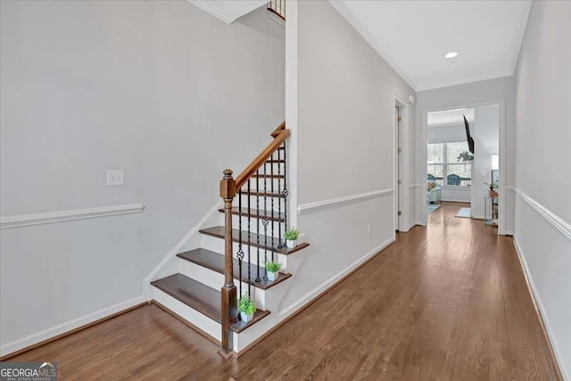 stairs with crown molding and hardwood / wood-style flooring