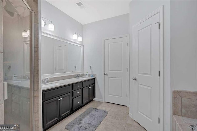 bathroom featuring tile patterned floors, vanity, and a shower with shower door