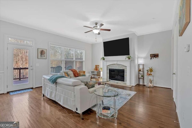 living room featuring ceiling fan, ornamental molding, and dark hardwood / wood-style flooring