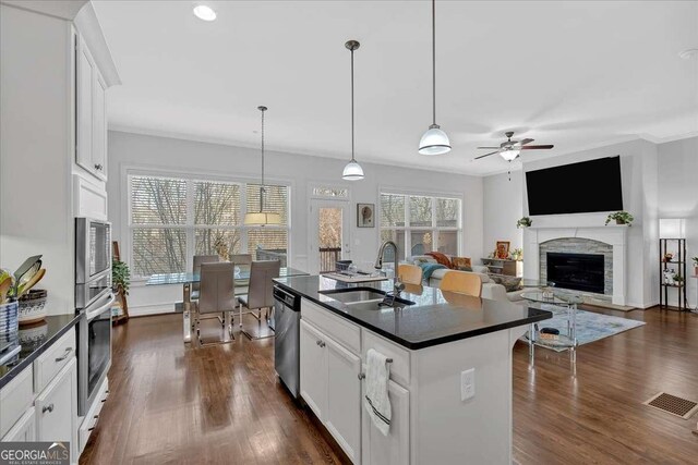 kitchen featuring white cabinetry, an island with sink, appliances with stainless steel finishes, and pendant lighting