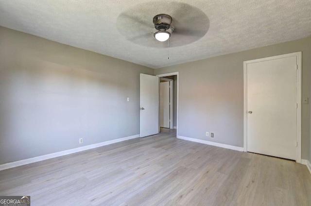 unfurnished room with ceiling fan, light hardwood / wood-style floors, and a textured ceiling