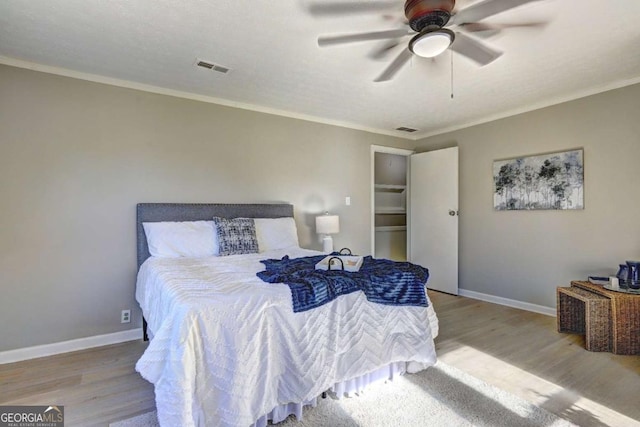 bedroom with crown molding, ceiling fan, and light wood-type flooring