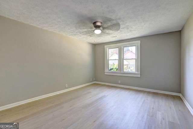 unfurnished room featuring ceiling fan, light hardwood / wood-style flooring, and a textured ceiling