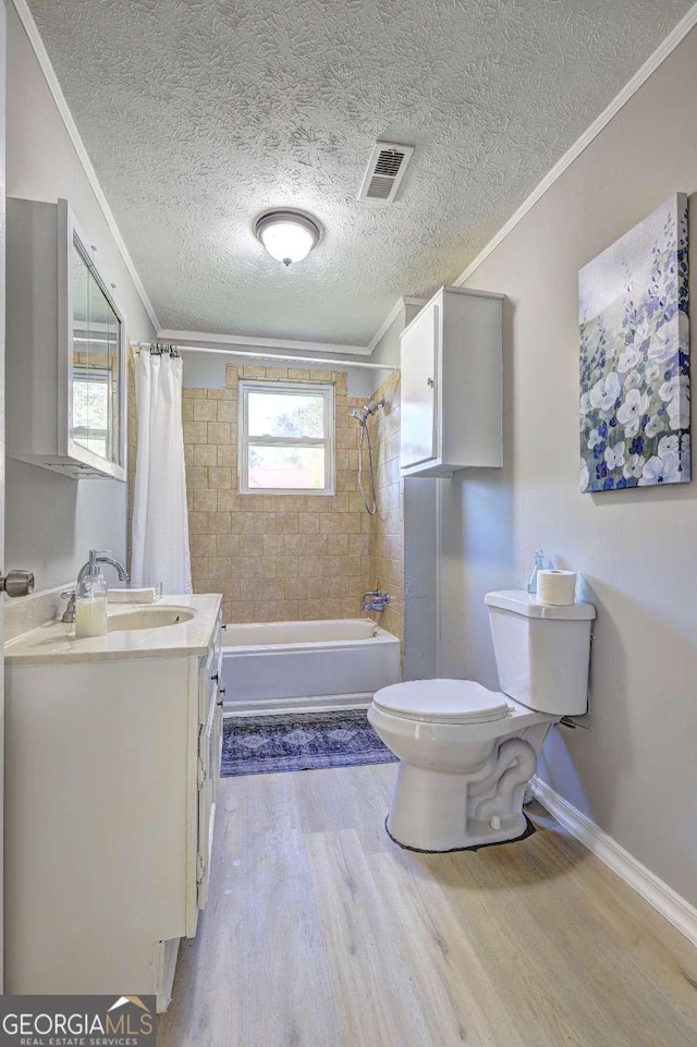 full bathroom with wood-type flooring, ornamental molding, vanity, shower / tub combo, and toilet