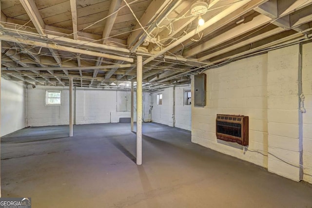 basement featuring electric panel and heating unit