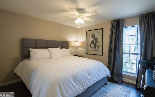 bedroom with dark hardwood / wood-style flooring and ceiling fan