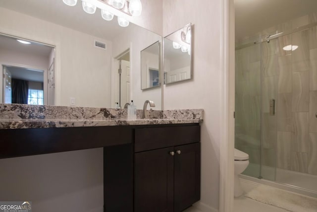 bathroom featuring toilet, vanity, and walk in shower