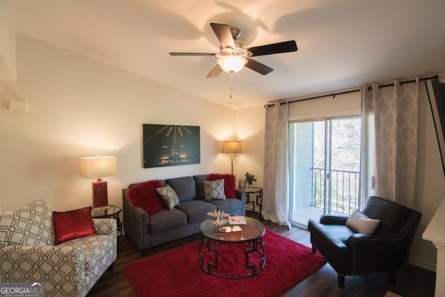 living room with dark wood-type flooring, ceiling fan, and vaulted ceiling