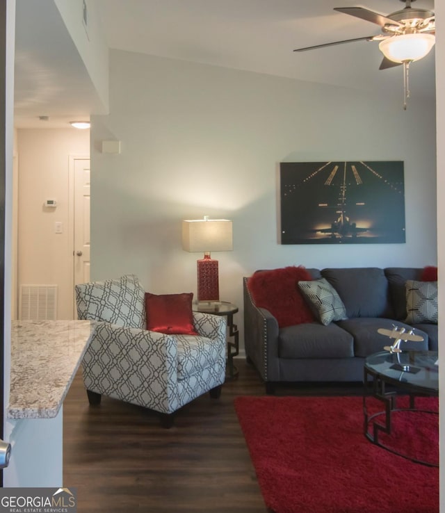 living room with dark wood-type flooring and ceiling fan