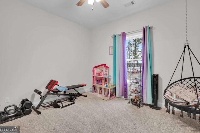 workout room featuring ceiling fan and carpet