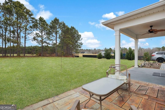 view of yard with ceiling fan and a patio