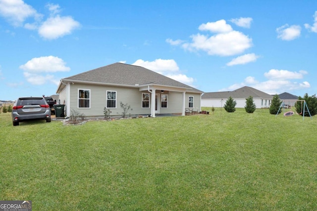 rear view of house featuring a yard and a playground