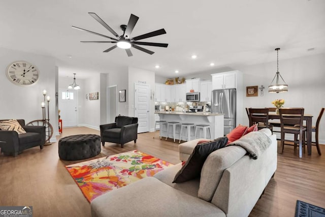 living room with ceiling fan and light hardwood / wood-style floors