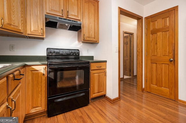 kitchen featuring electric range and light hardwood / wood-style flooring