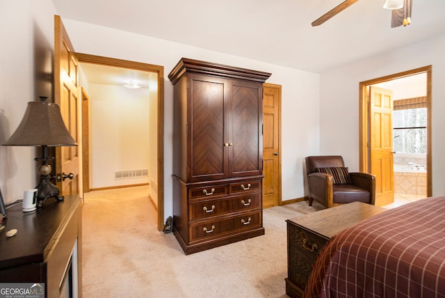 bedroom featuring ceiling fan, ensuite bathroom, and light carpet