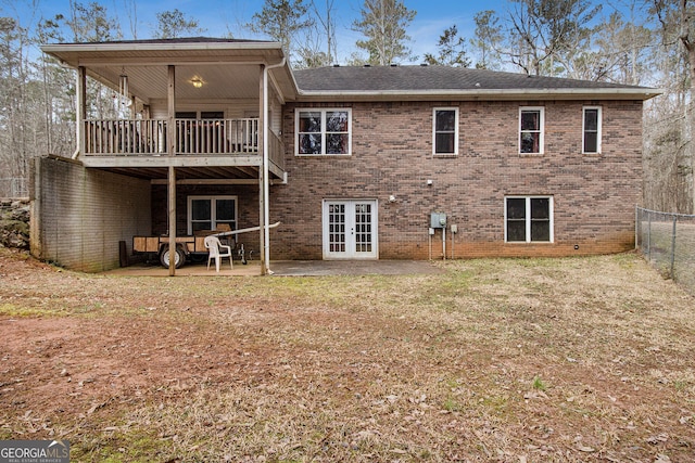 back of property featuring a balcony, a yard, a patio area, and french doors