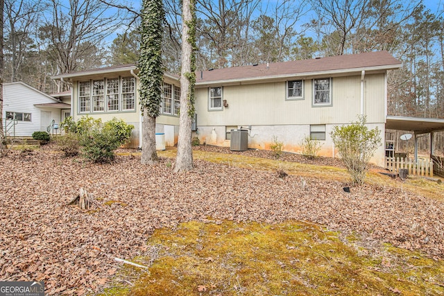 rear view of property featuring a carport and central air condition unit