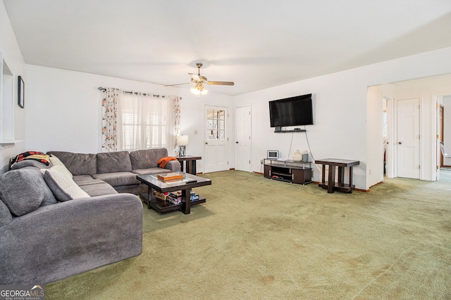 carpeted living room with ceiling fan