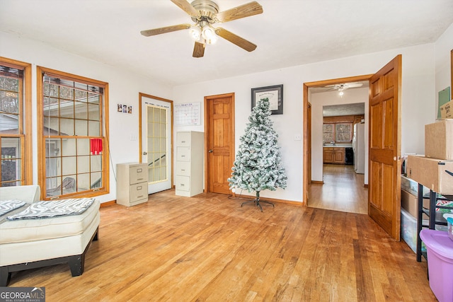 sitting room with ceiling fan, a healthy amount of sunlight, and light hardwood / wood-style floors