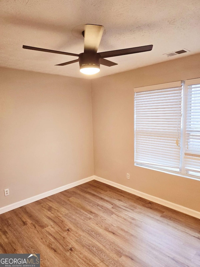 unfurnished room featuring hardwood / wood-style floors, a textured ceiling, and ceiling fan