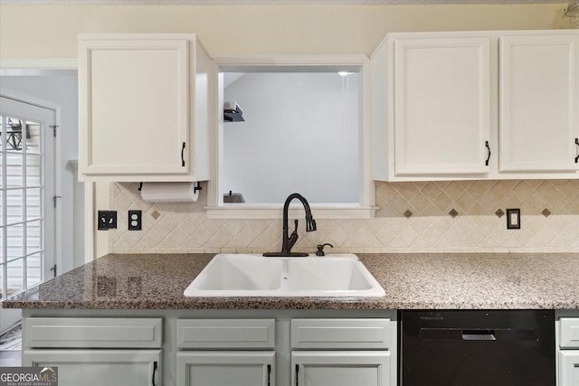 kitchen with sink, stone countertops, dishwasher, white cabinets, and backsplash