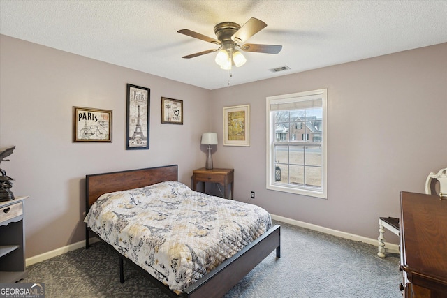 carpeted bedroom featuring ceiling fan and a textured ceiling