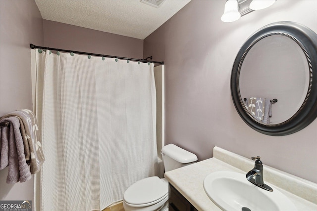 bathroom featuring vanity, toilet, and a textured ceiling