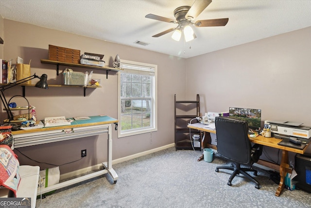 carpeted office featuring ceiling fan and a textured ceiling