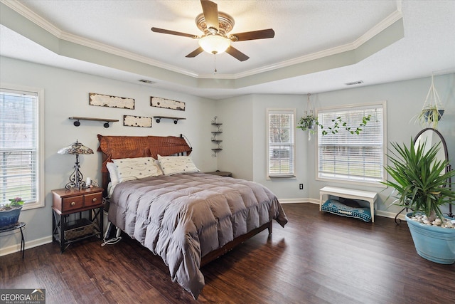 bedroom featuring dark hardwood / wood-style floors, ornamental molding, ceiling fan, a raised ceiling, and a textured ceiling