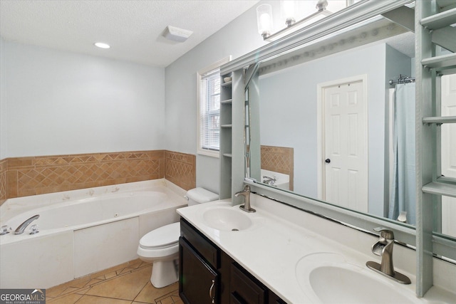 bathroom with a washtub, vanity, a textured ceiling, tile patterned floors, and toilet