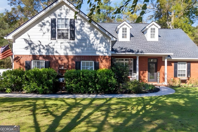 cape cod home featuring a front yard