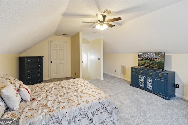 carpeted bedroom with ceiling fan, lofted ceiling, and a textured ceiling