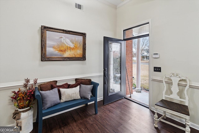 foyer entrance with ornamental molding and dark hardwood / wood-style floors