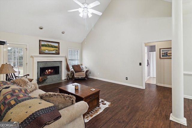 living room with ceiling fan, high vaulted ceiling, decorative columns, a fireplace, and dark hardwood / wood-style flooring