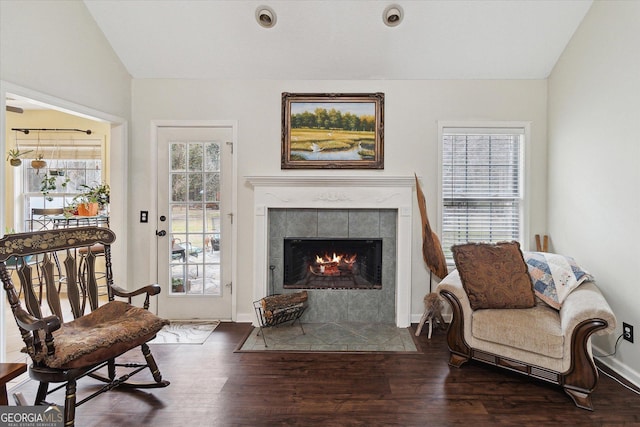 sitting room with vaulted ceiling, dark wood-type flooring, and a fireplace