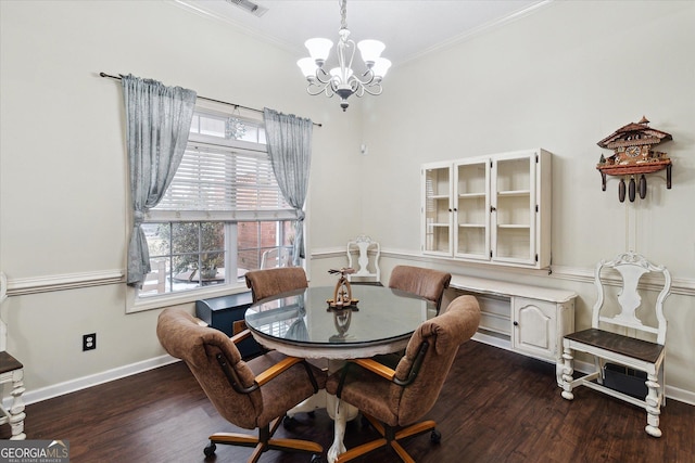 dining space featuring crown molding, dark wood-type flooring, and a chandelier