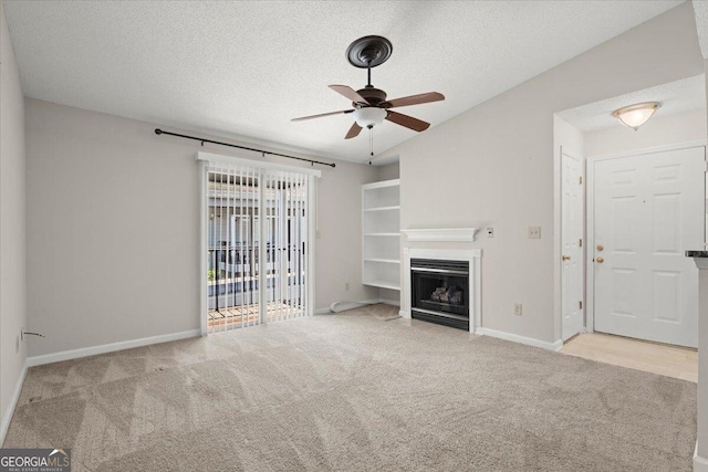 unfurnished living room with ceiling fan, light colored carpet, and a textured ceiling