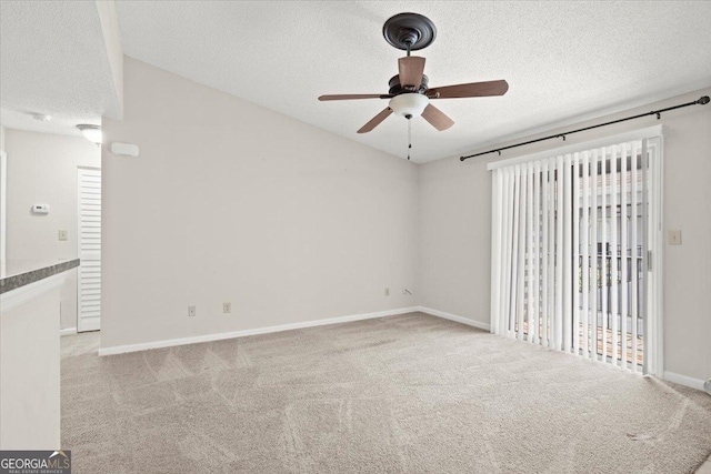 carpeted empty room with ceiling fan and a textured ceiling