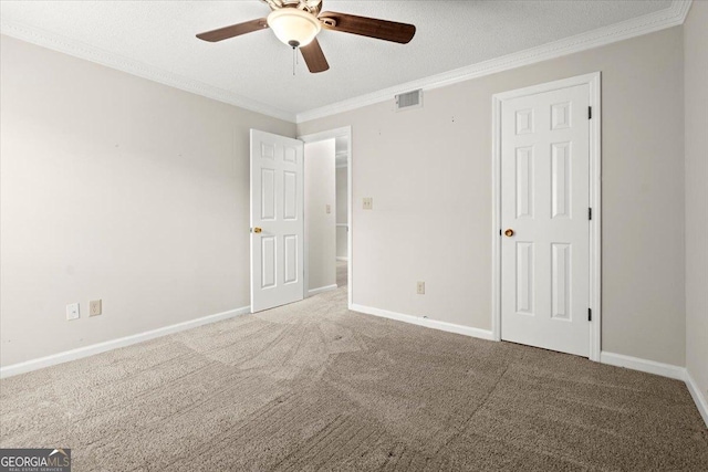 unfurnished room featuring ornamental molding, carpet, ceiling fan, and a textured ceiling