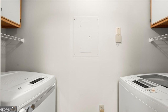 laundry room with independent washer and dryer, cabinets, and electric panel