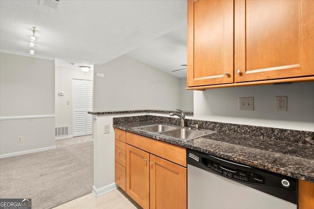 kitchen with sink, a textured ceiling, dark stone countertops, dishwasher, and light colored carpet