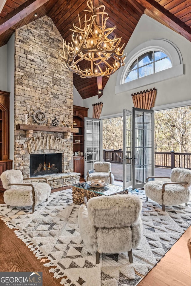 living room featuring wood ceiling, wood-type flooring, a chandelier, high vaulted ceiling, and a fireplace