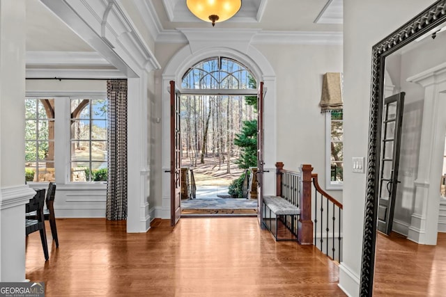 entryway with wood-type flooring and ornamental molding