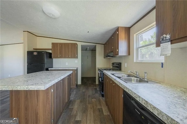 kitchen featuring black appliances, light countertops, and a sink