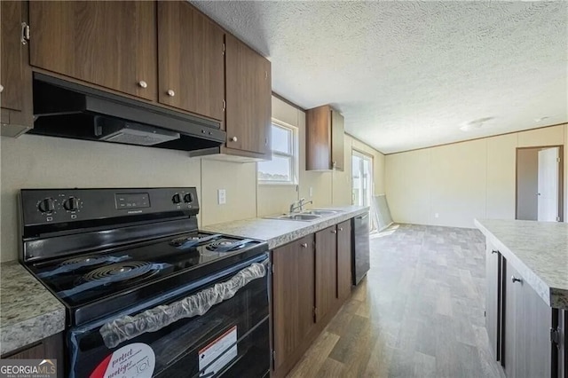 kitchen with electric range, dishwasher, light countertops, under cabinet range hood, and a sink