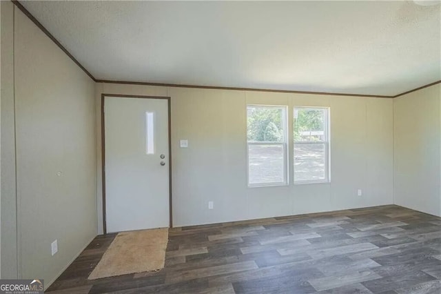 empty room with dark wood-style floors, crown molding, and a textured ceiling